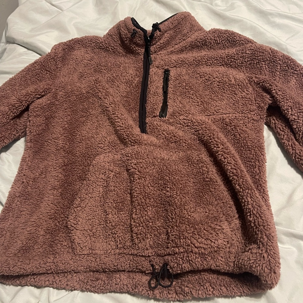 Picture looks brown but it’s more of a pink color. Brand pink, jacket. No hood.